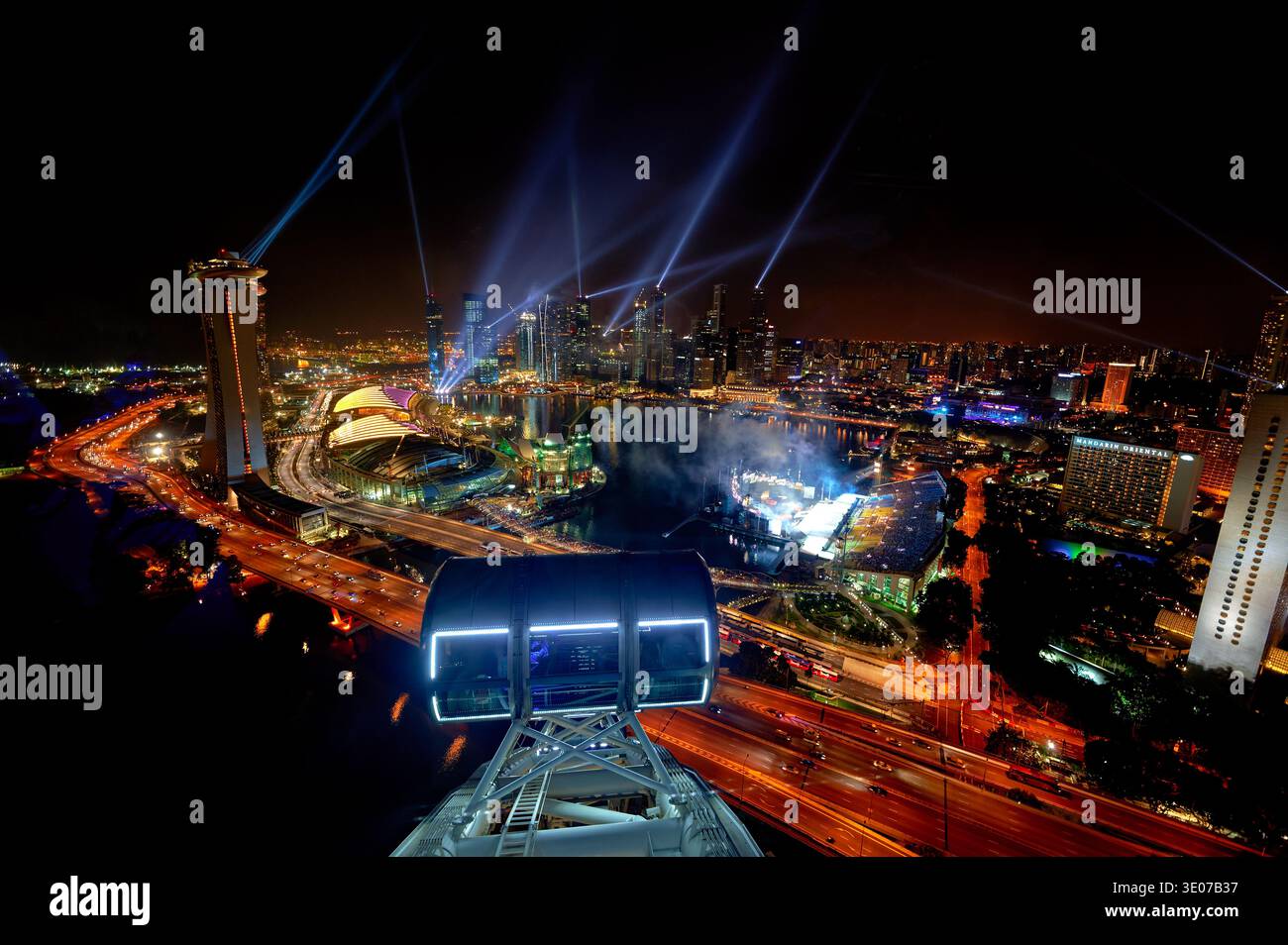 La città di Singapore è visibile dal Flyer di notte. Gli edifici brillano mentre le luci illuminano lo skyline e le strade sottostanti. Foto Stock