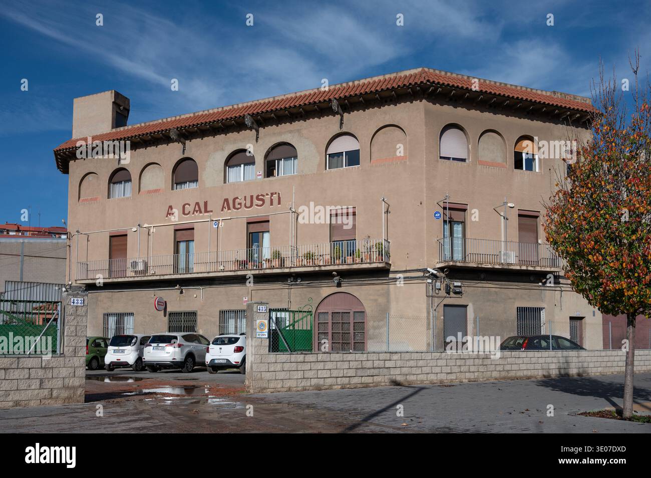 Facciata di Cal Agusti, una tradizionale fattoria storica catalana masia integrata nel paesaggio urbano di Barcellona sotto un cielo azzurro. Foto Stock