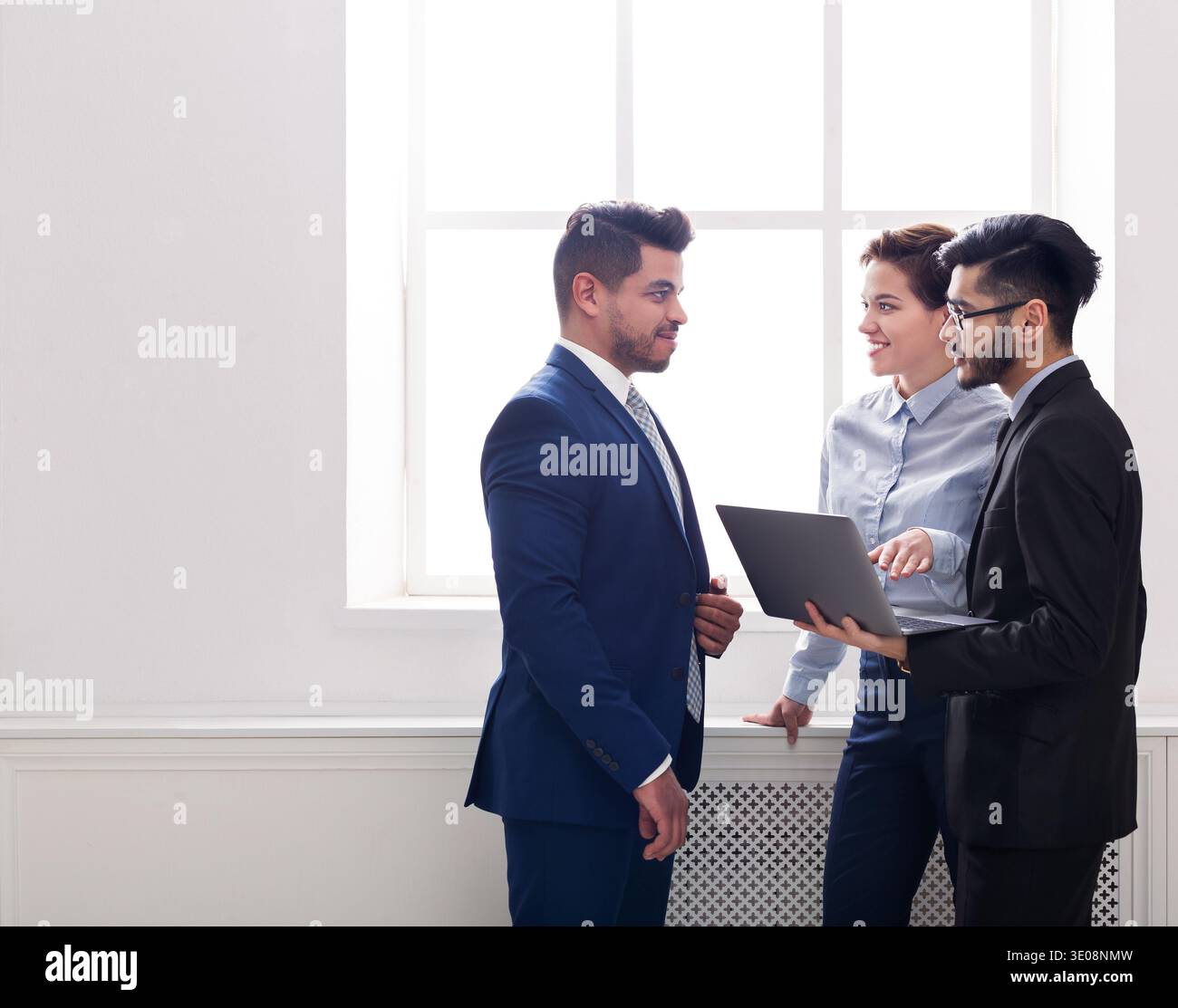 Colleghi di lavoro avente una conversazione in ufficio vicino alla finestra Foto Stock