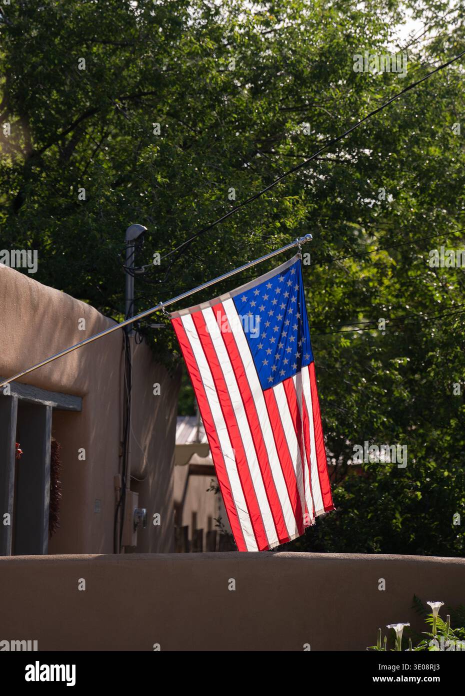 Bandiera degli stati uniti d'america bandiera degli stati uniti stelle e strisce bandiera degli Stati Uniti appesa davanti alla casa in stile adobe a santa fe, New mexico patriottismo Foto Stock