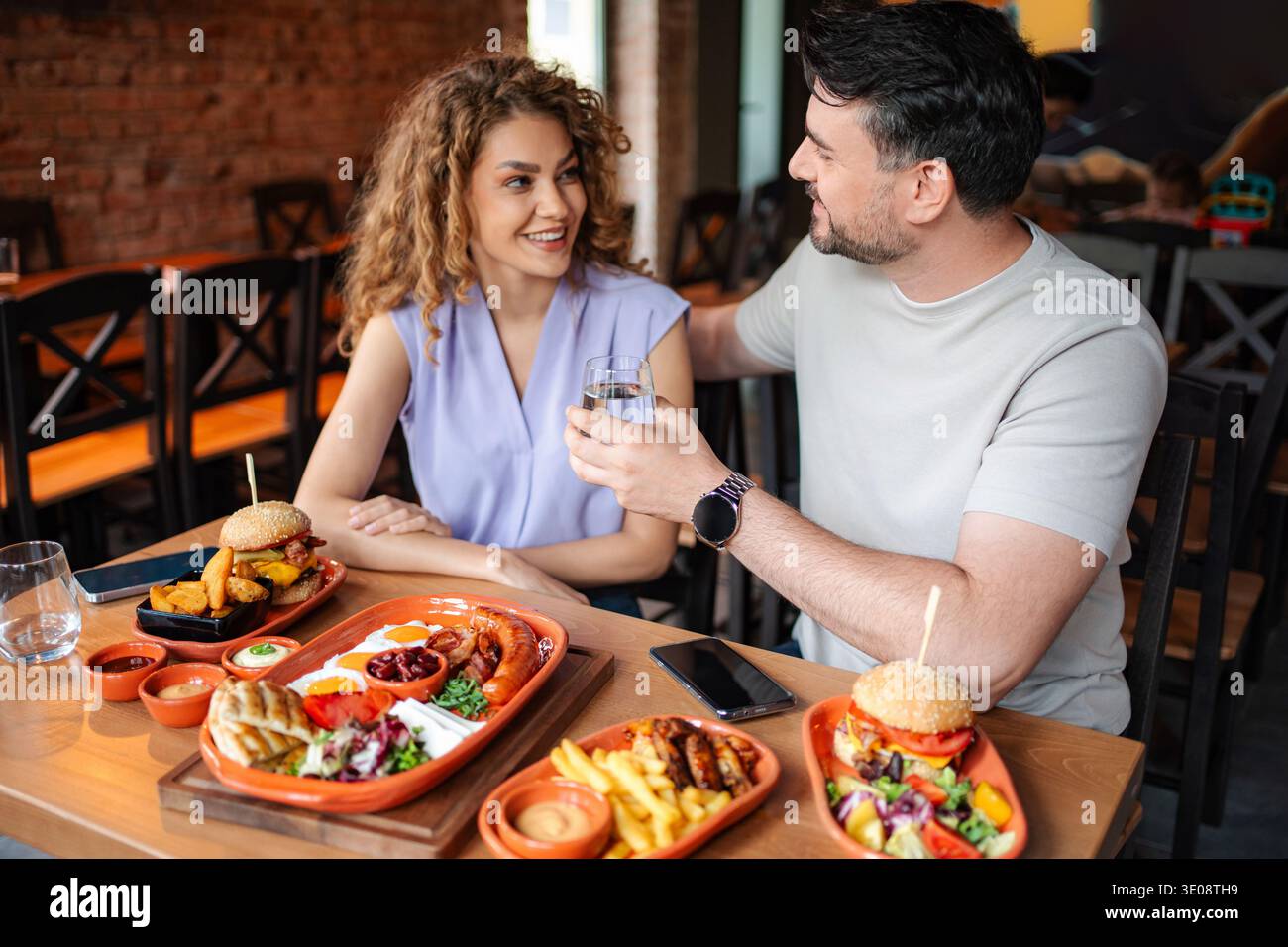Coppia felice che brinda con acqua in un ristorante Foto Stock