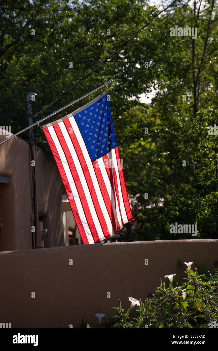 Bandiera degli stati uniti d'america bandiera degli stati uniti stelle e strisce bandiera degli Stati Uniti appesa davanti alla casa in stile adobe a santa fe, New mexico patriottismo Foto Stock