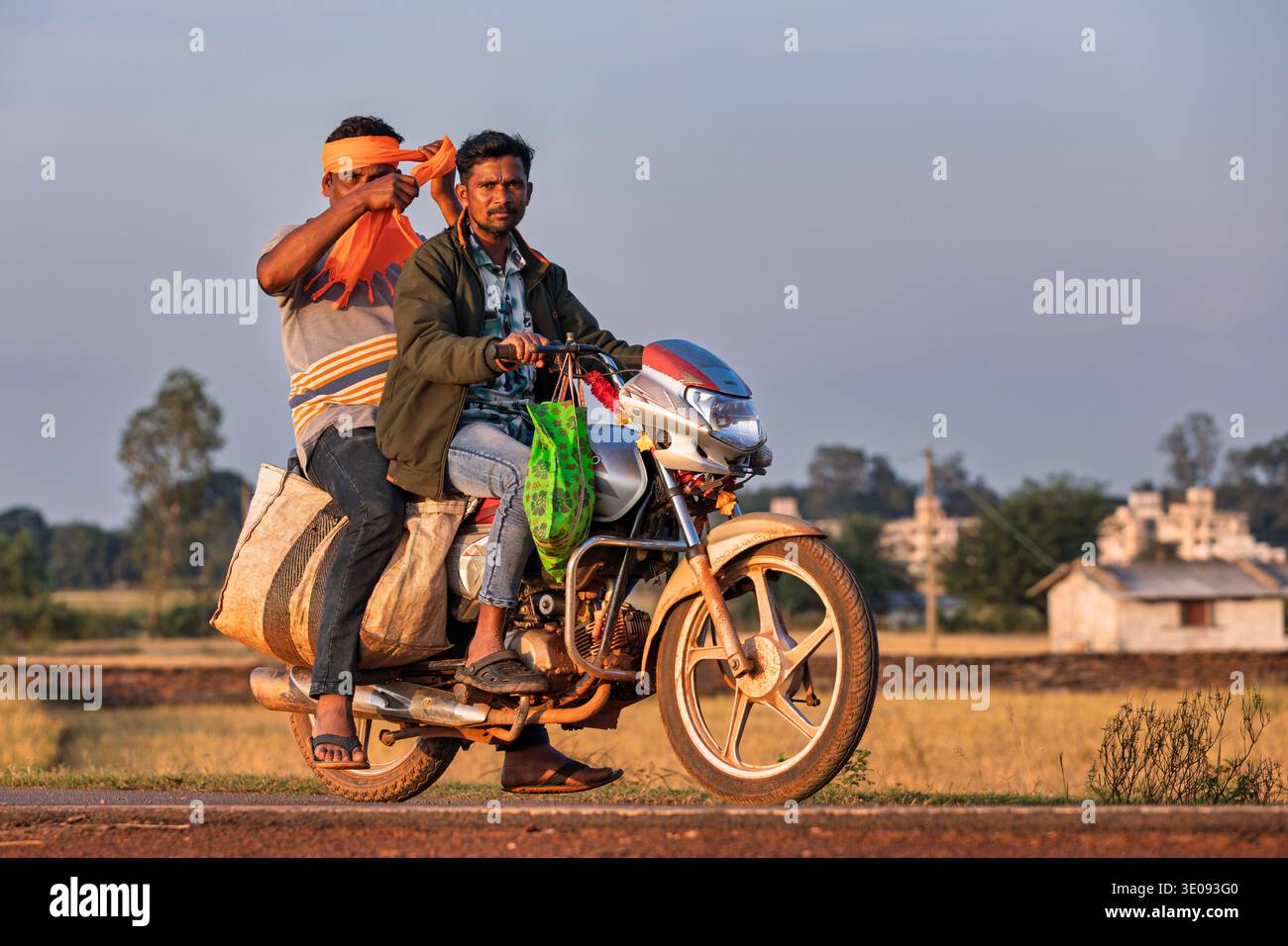 Uomini di ritorno da un mercato locale in moto, Chhattisgarh, India Foto Stock