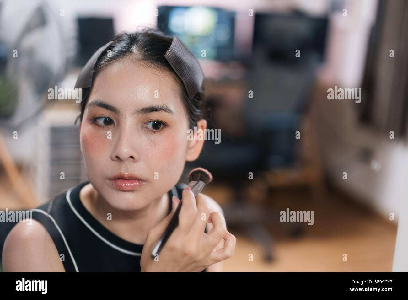 Ritratto ravvicinato di attraente donna asiatica che si prepara ad applicare cosmetici, spazzola per il trucco del viso, toelettatura dialy, applicazione cosmetica e auto c Foto Stock