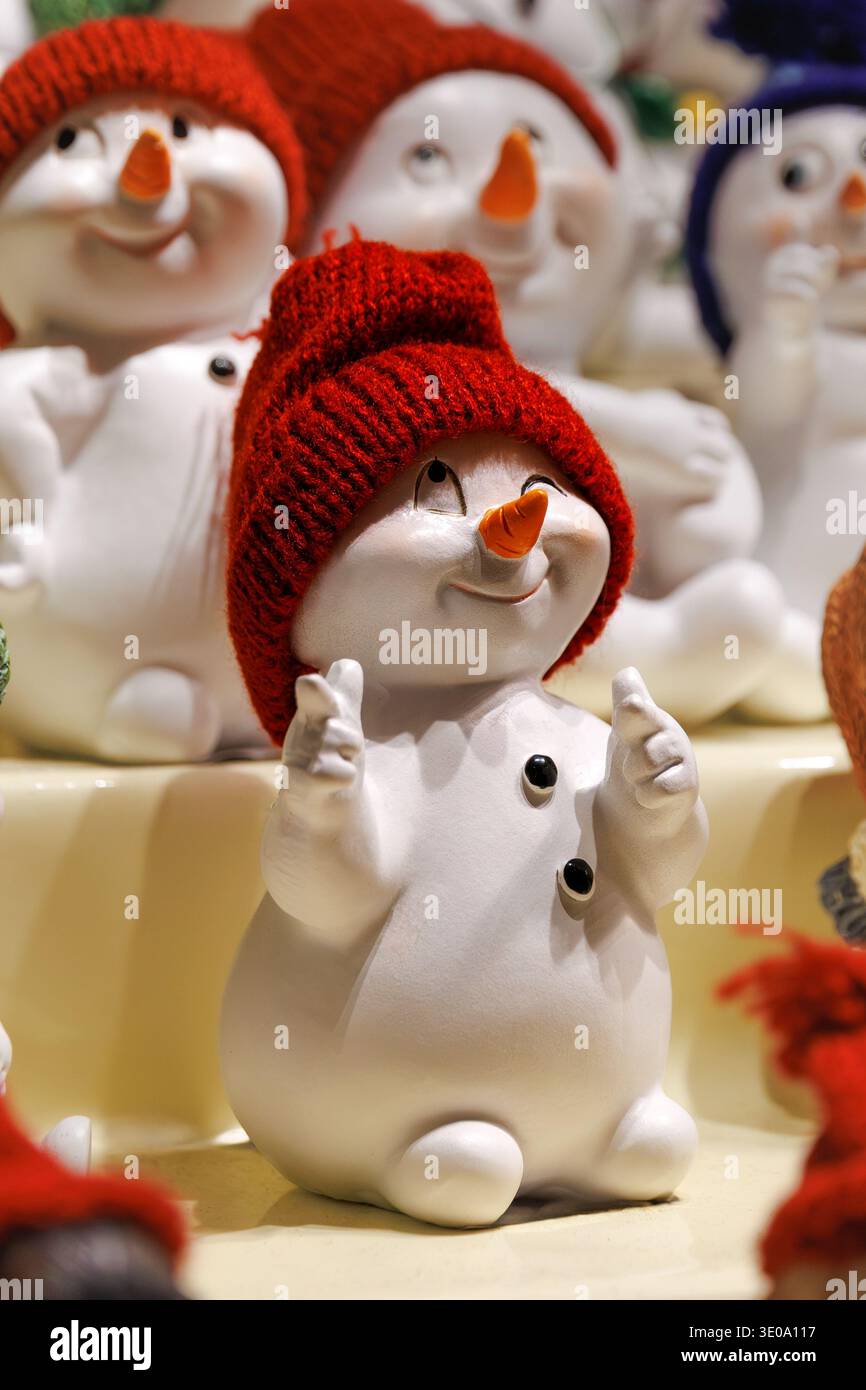 Graziosa statuina di pupazzo di neve con cappello rosso lavorato a maglia al mercatino di Natale Foto Stock