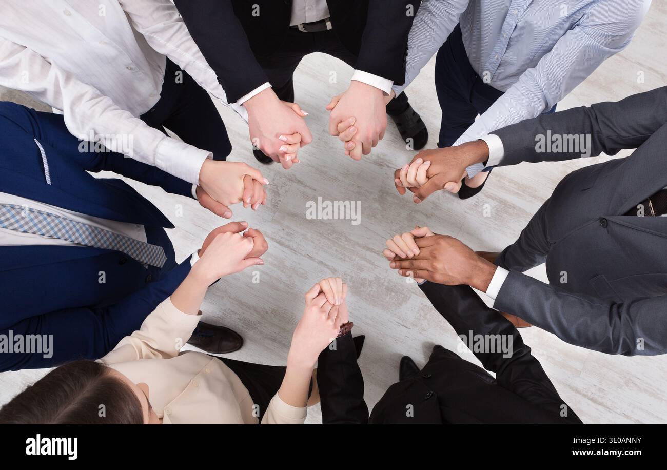 Colleghi d'affari che tengono le mani unite, vista dall'alto Foto Stock