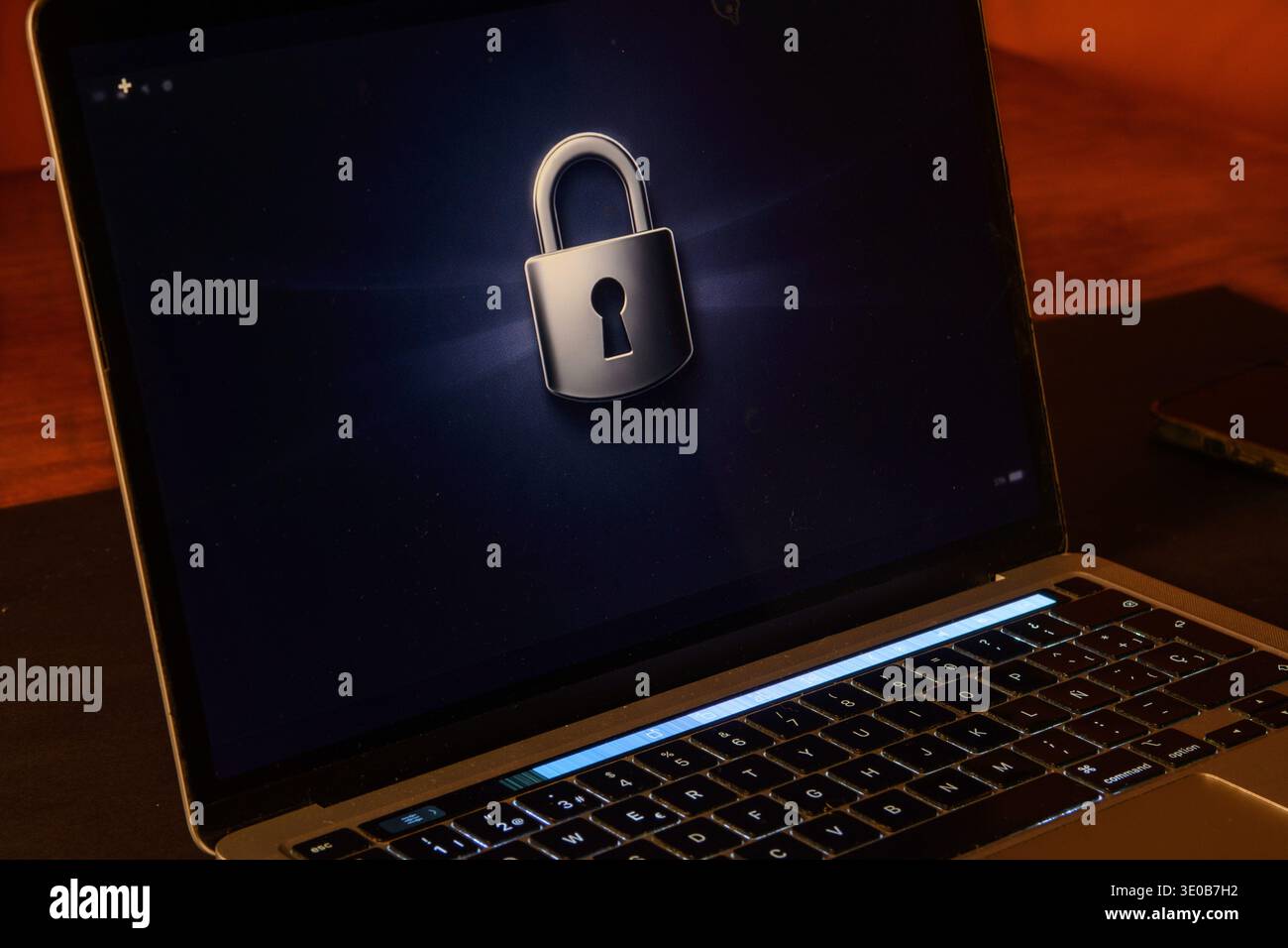 Notebook con un simbolo di lucchetto su uno schermo scuro, immagine concettuale di protezione dei dati, sicurezza dei dispositivi, privacy, crittografia e accesso digitale sicuro. Foto Stock