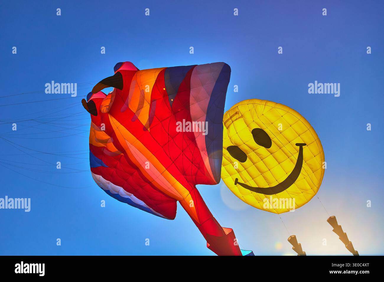 Coloratissimi aquiloni e Smiley Face in Blue Sky al Kite Festival Sunlight Perspective Foto Stock