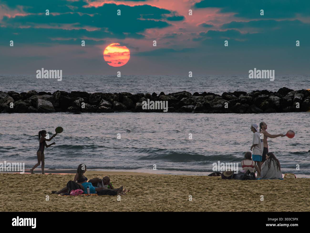 I giovani giocano a paddleball (matkot) sulla spiaggia di Tel Aviv al tramonto-3 Foto Stock