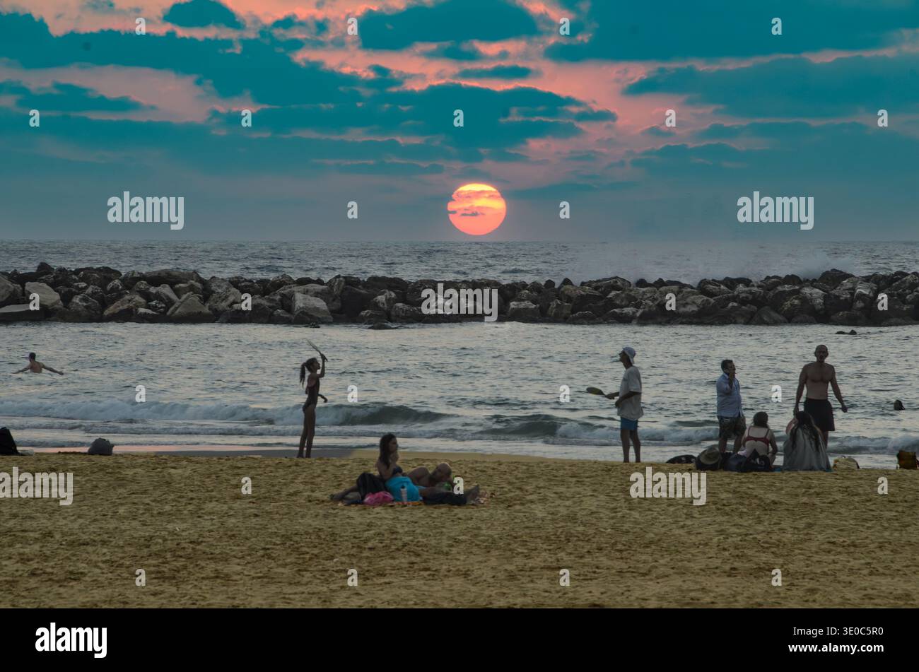 I giovani giocano a paddleball (matkot) sulla spiaggia di Tel Aviv al tramonto-2 Foto Stock