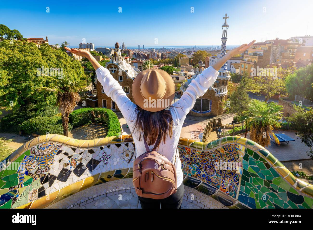 Una donna turistica felice gode della vista del famoso Parco Güell di Barcellona, in Spagna, in una giornata di sole Foto Stock