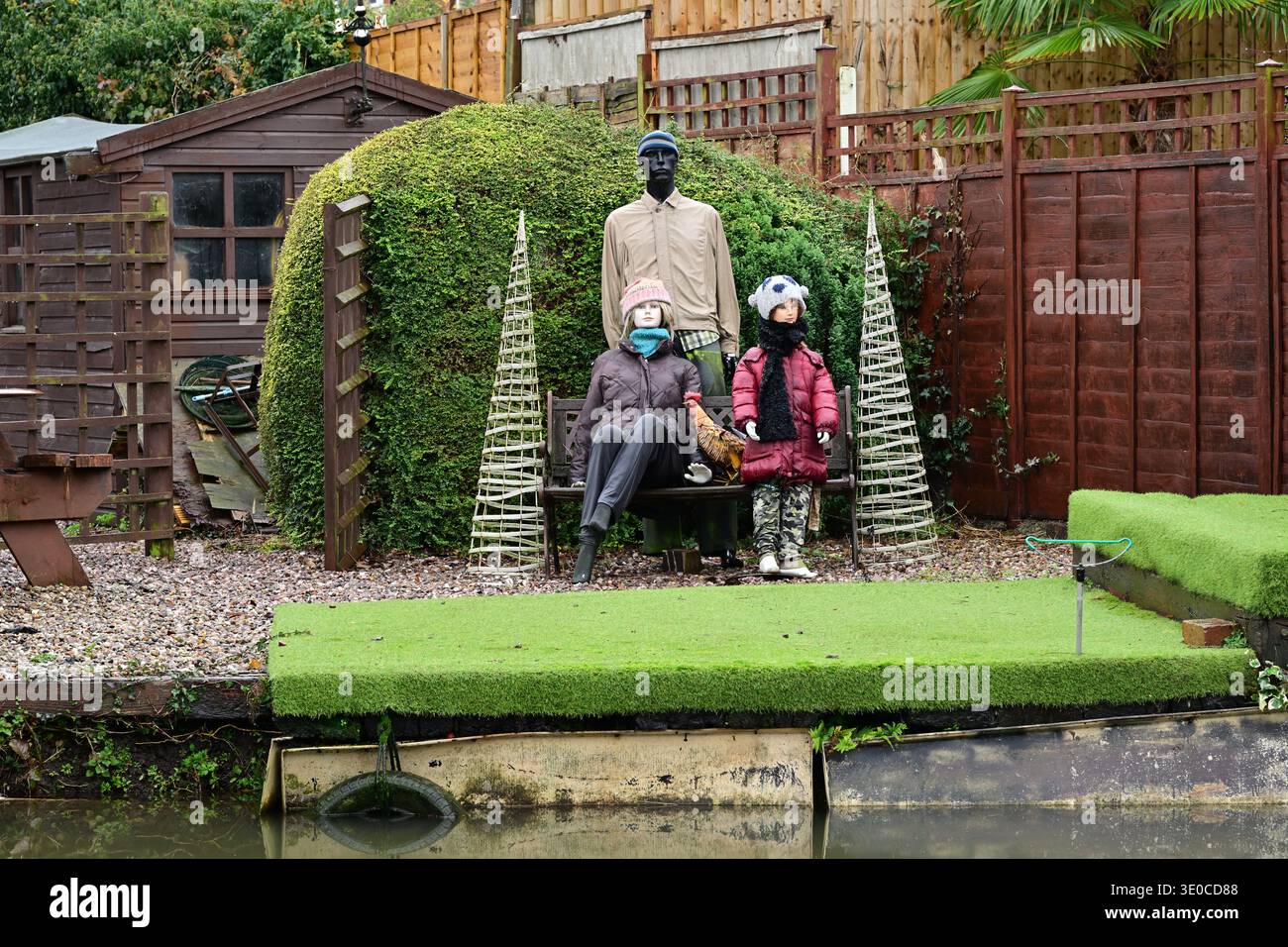7 dicembre 2025, Atherstone, Regno Unito: Stravagante scena del giardino con manichini in posa come una famiglia all'aperto Foto Stock