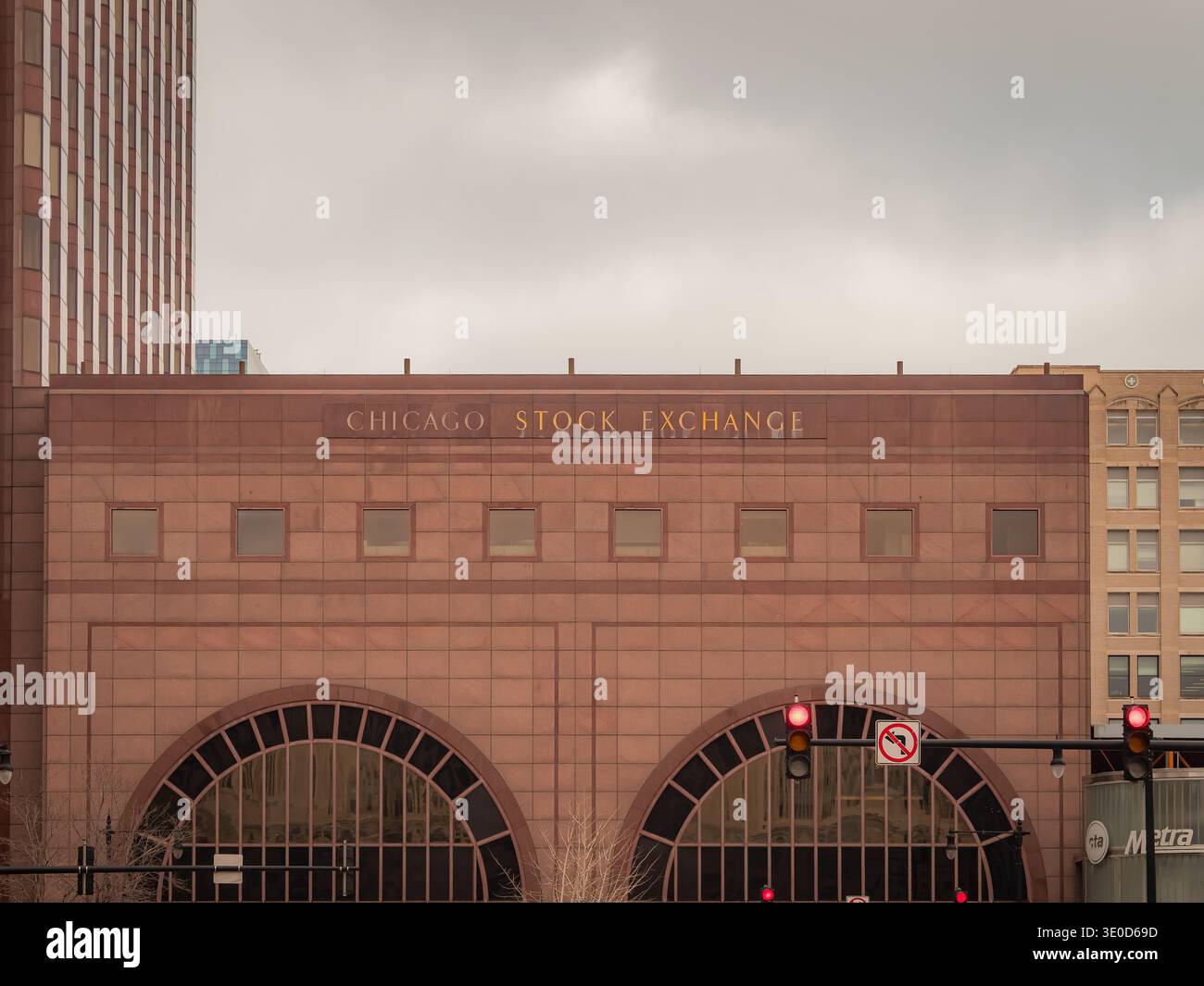 Facciata della Borsa di Chicago con scritta oro, finestre ad arco, semafori rossi e cielo coperto nel centro di Chicago Foto Stock