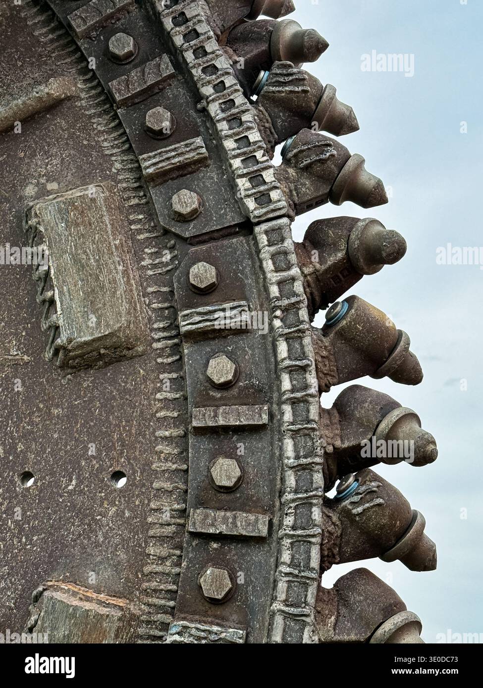 I denti di un escavatore vengono utilizzati per scavare trincee in linea retta. Foto Stock