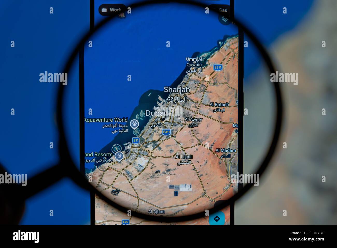 Lente di ingrandimento sullo schermo dello smartphone che visualizza la mappa di Dubai e Sharjah negli Emirati Arabi Uniti, pianificazione del viaggio e concetto di navigazione su Google Maps Foto Stock