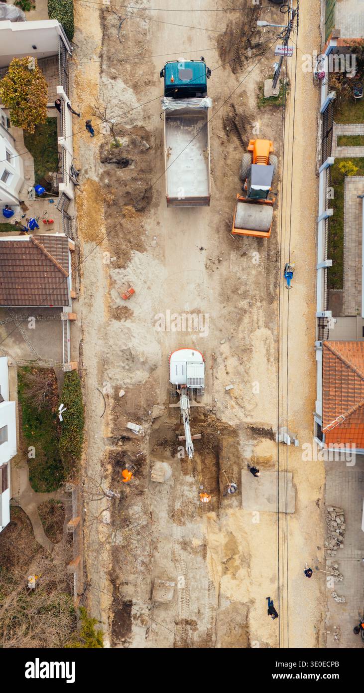Vista aerea delle attrezzature da costruzione e dei lavoratori in mezzo alla terra polverosa, in contrasto con gli edifici circostanti, Belgrado, città di Belgrado, serba Foto Stock