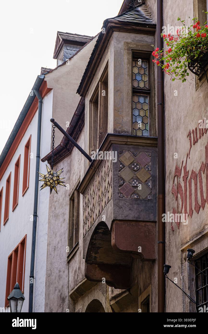 Facciata di un edificio storico con balcone decorativo e vetrate colorate nella città europea Foto Stock