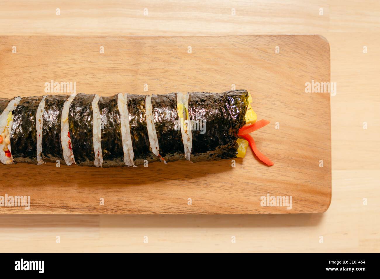 Rotolo di gimbap coreano su un asse di legno Foto Stock