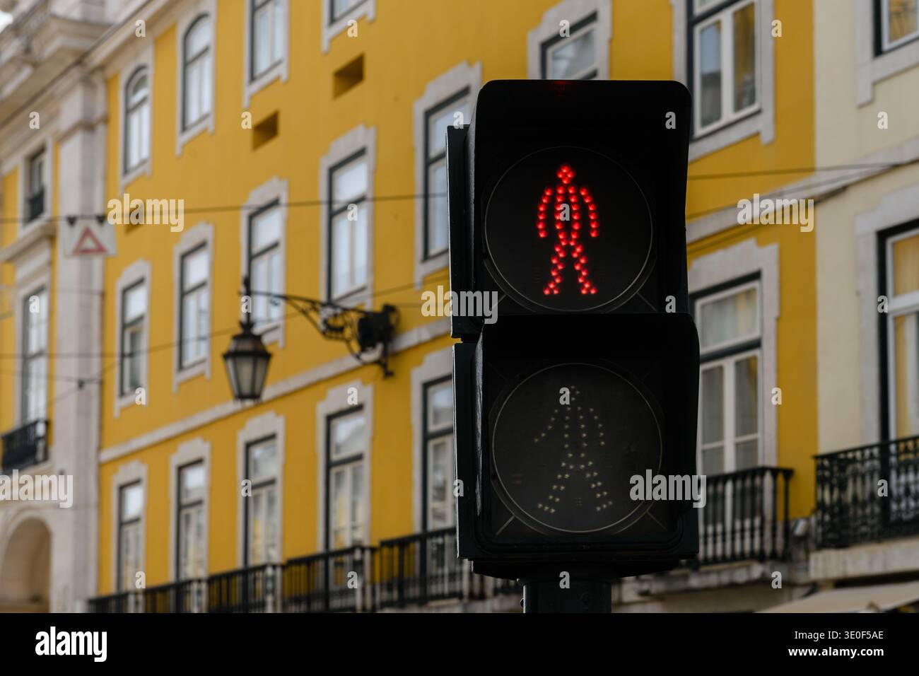 Semaforo pedonale su una strada Lisbona, Portogallo, con uomo fisso rosso che indica che non è sicuro per i pedoni attraversare la strada. Foto Stock