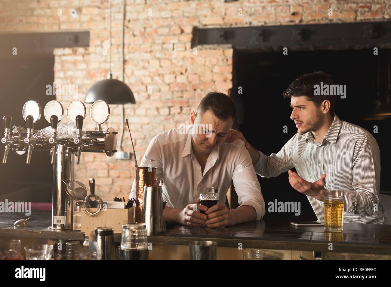 Consolando il suo amico depresso al bar Foto Stock