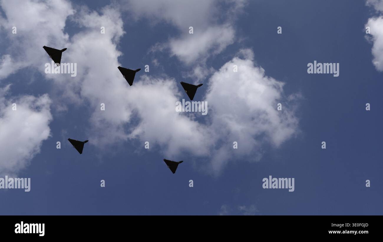 Sciame di droni di attacco militari a forma di ala delta nel cielo - rendering 3D. Foto Stock