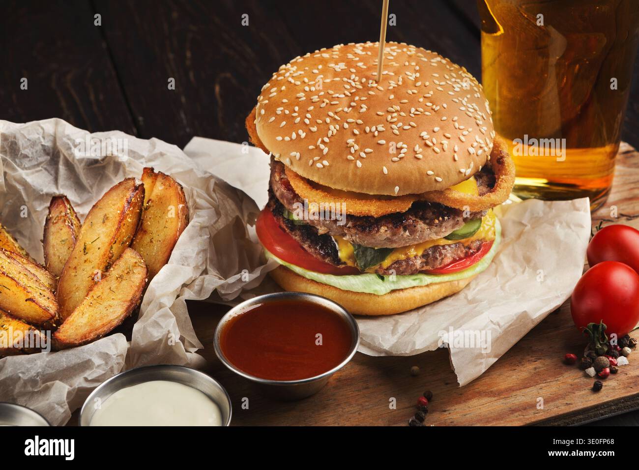 Hamburger e patate serviti con birra al ristorante, primo piano Foto Stock