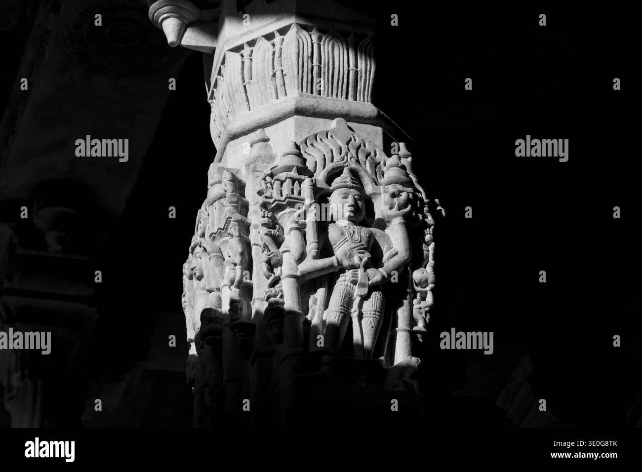 Dettagliate sculture su una delle colonne di marmo all'interno del Tempio Jain di Ranakpur, finemente intagliato. Foto monocromatica in scala di grigi. Rajasthan, India Foto Stock