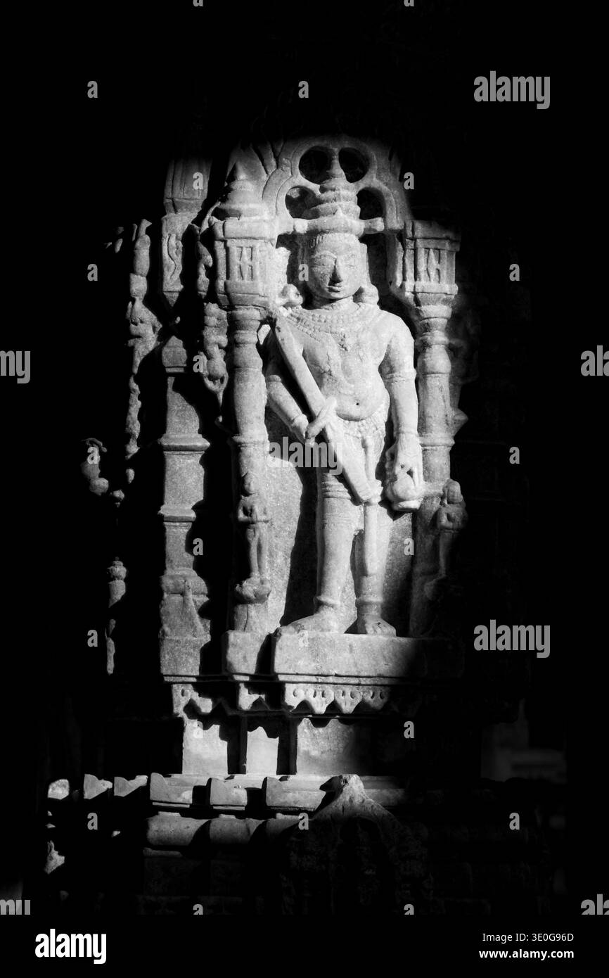 Dettagliate sculture su una delle colonne di marmo all'interno del Tempio Jain di Ranakpur, finemente intagliato. Foto monocromatica in scala di grigi. Rajasthan, India Foto Stock