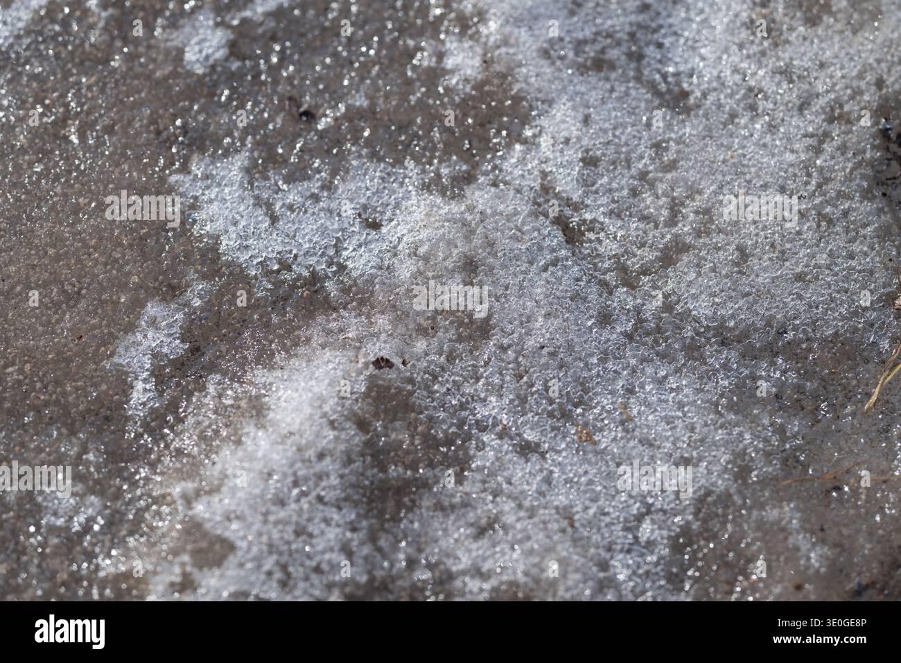 Ghiaccio scintillante. Brilla di ghiaccio primaverile con il gelo. Le particelle congelate brillano man mano che il ghiaccio si scioglie. Polvere e ombre cristalline brillanti segnano lo scioglimento del ghiaccio Foto Stock