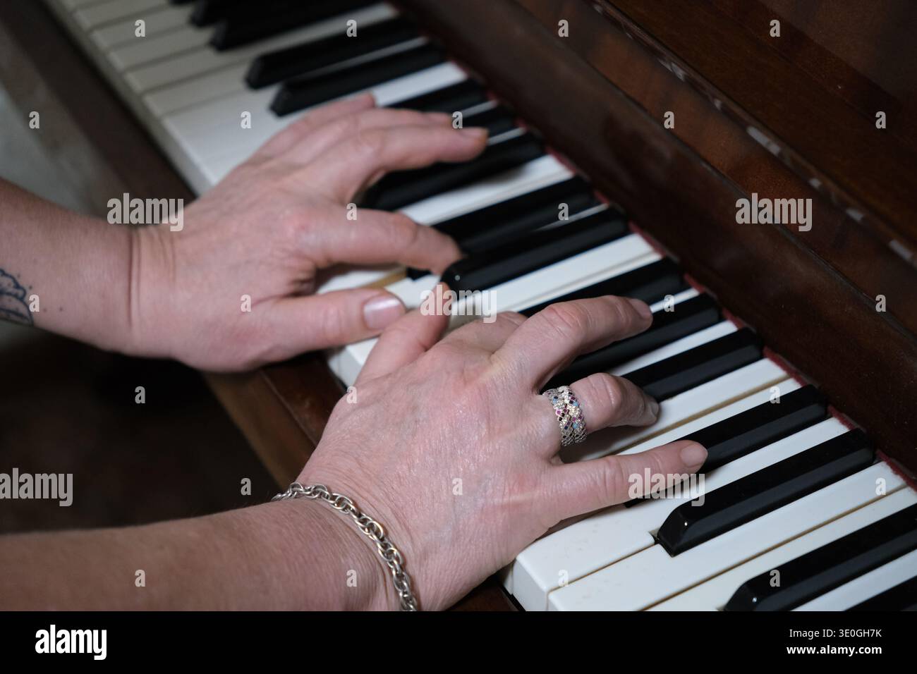Primo piano di mani che suonano il piano. Mettere a fuoco le dita premendo i tasti Foto Stock