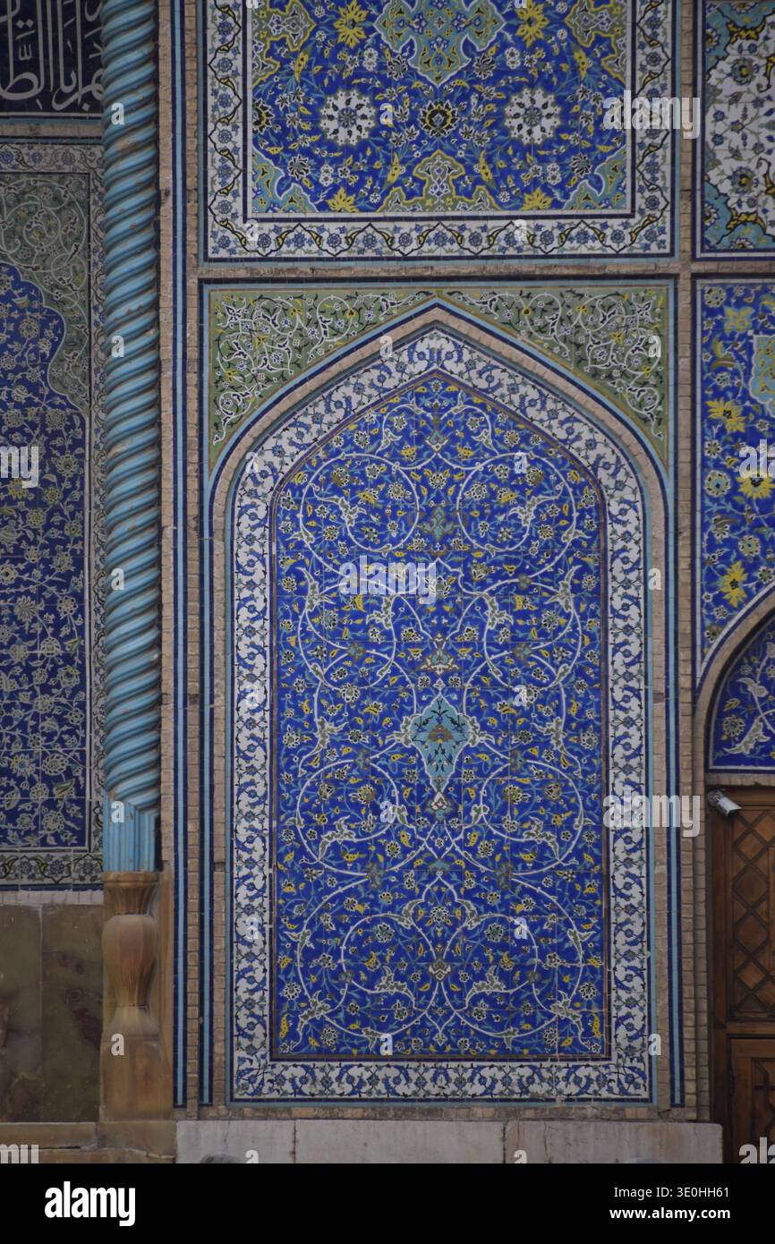 Pannello verticale di piastrelle blu della moschea persiana con motivi floreali arabeschi e arco islamico a punta nella storica Isfahan, Iran. Foto Stock