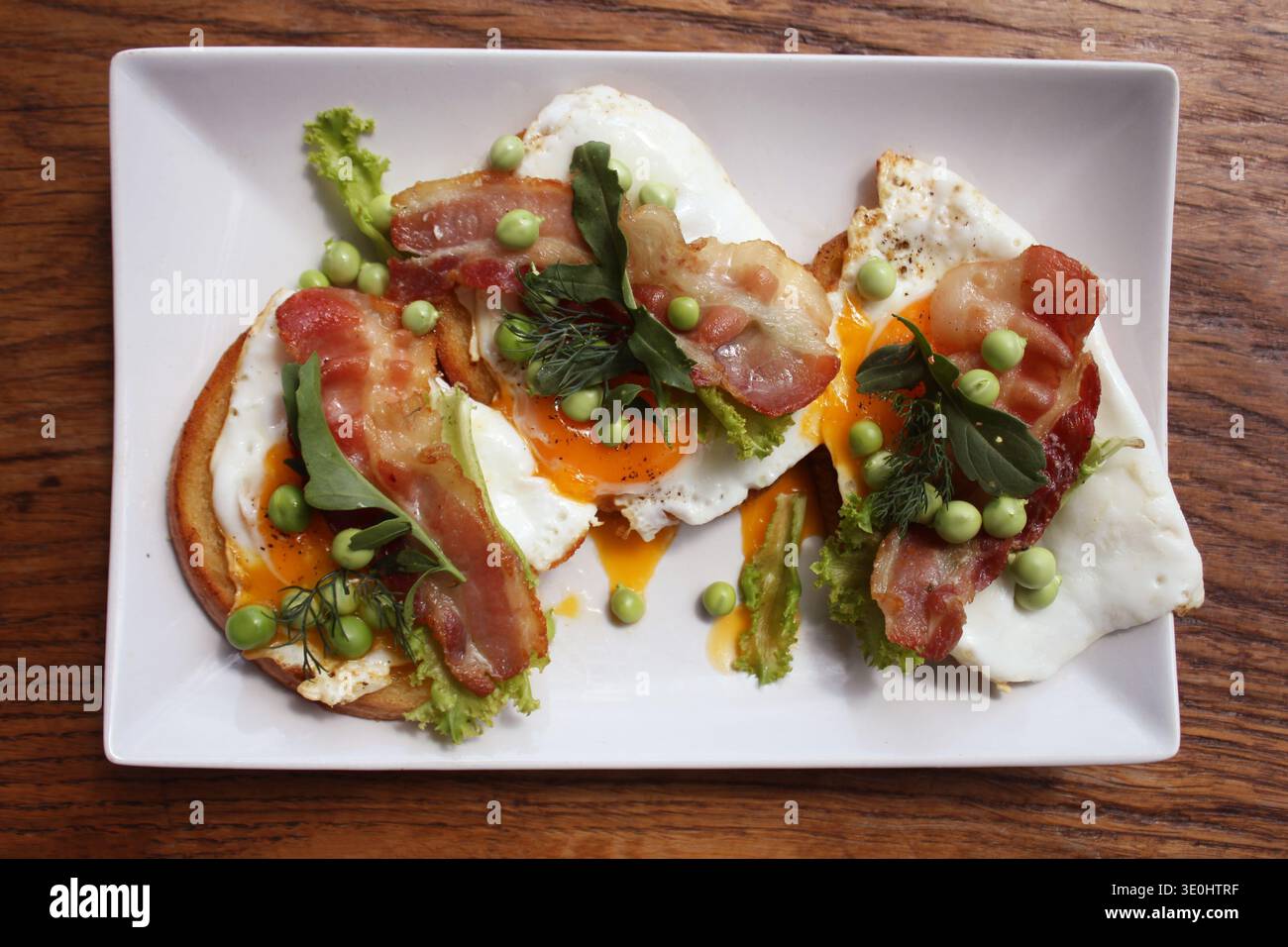 Panini a vista con uova fritte, pancetta e piselli Foto Stock