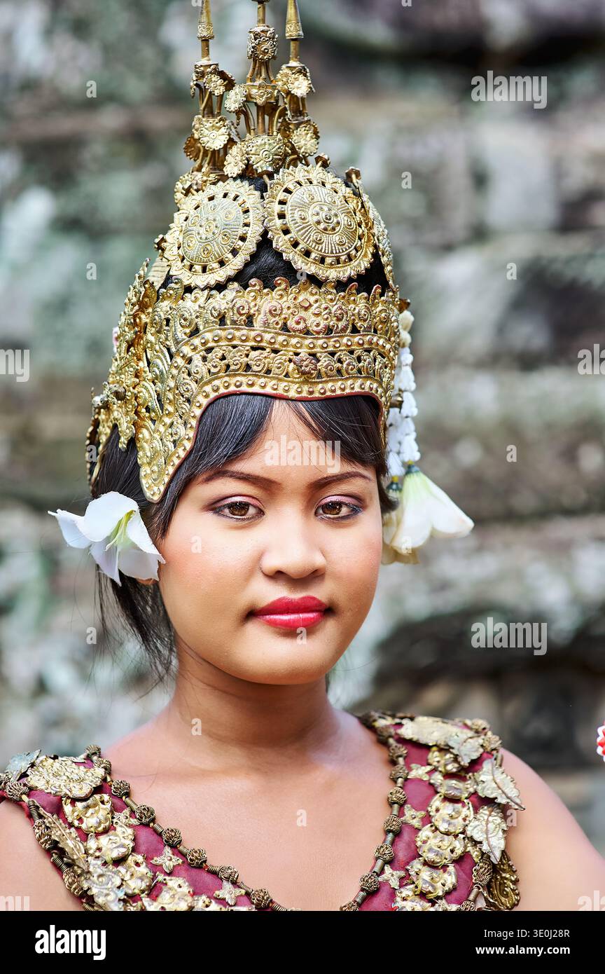 Una ballerina cambogiana dell'Apsara indossa un copricapo dorato e un costume decorato mentre si esibisce in un antico tempio in Cambogia. Foto Stock
