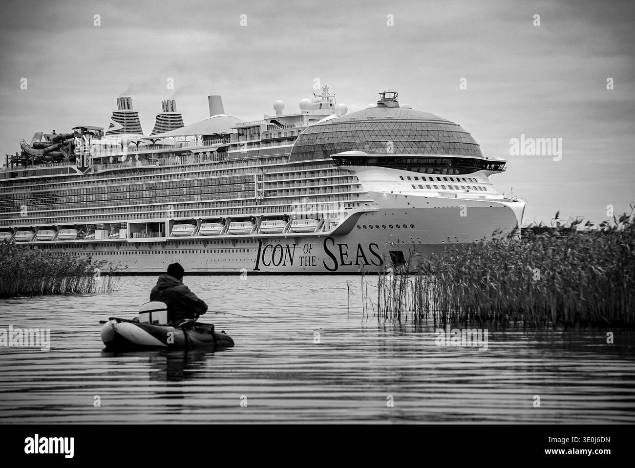 TURKU, FINLANDIA - SETTEMBRE 2023: Un pescatore solitario in un tubo galleggiante, oscurato dalla più grande nave da crociera del mondo, icona dei mari Foto Stock