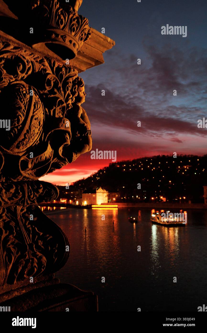 Statua storica del Ponte Carlo che si affaccia sul fiume Moldava al tramonto a Praga, Repubblica Ceca. Foto Stock