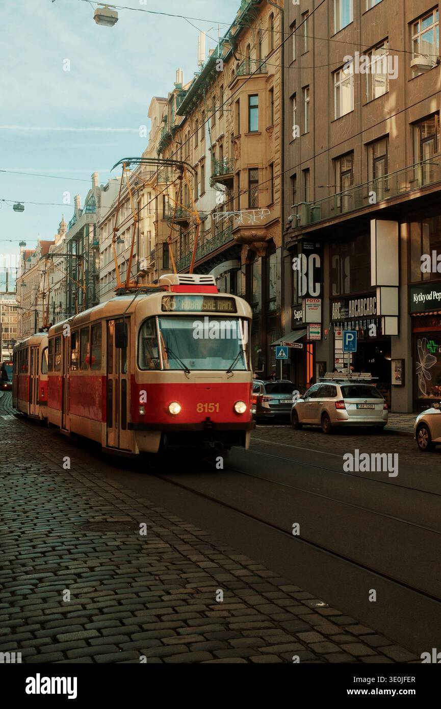 Tradizionale tram rosso di Praga che attraversa la strada acciottolata della città vecchia di Praga, Repubblica Ceca Foto Stock