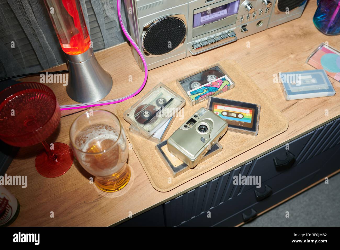 Cassette audio vintage e telecamera retrovisiva disposte su un tavolo in legno Foto Stock