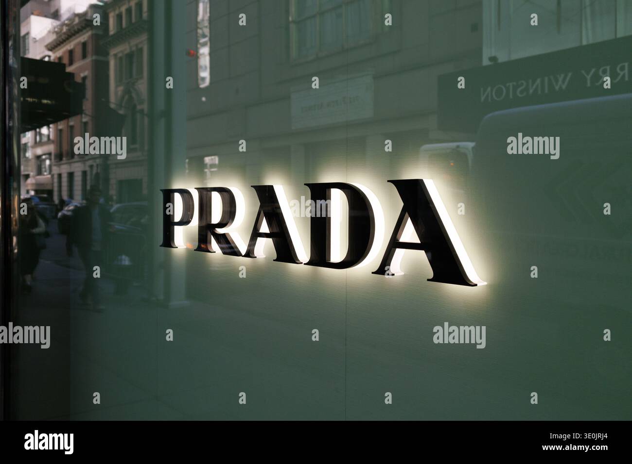 Insegna illuminata del negozio Prada con riflessi stradali alla vetrina sulla Fifth Avenue, Midtown Manhattan, New York City, USA Foto Stock