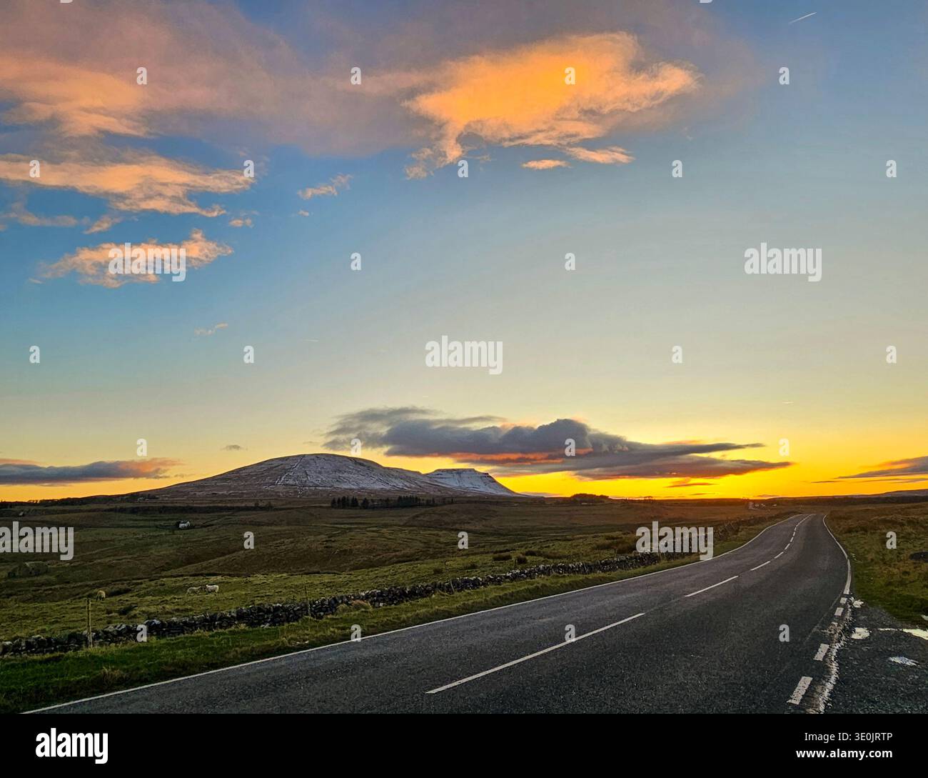 Ingleborough al tramonto, Yorkshire Dales National Park. Neve sulle colline alla fine di novembre e un cielo spettacolare. Foto Stock
