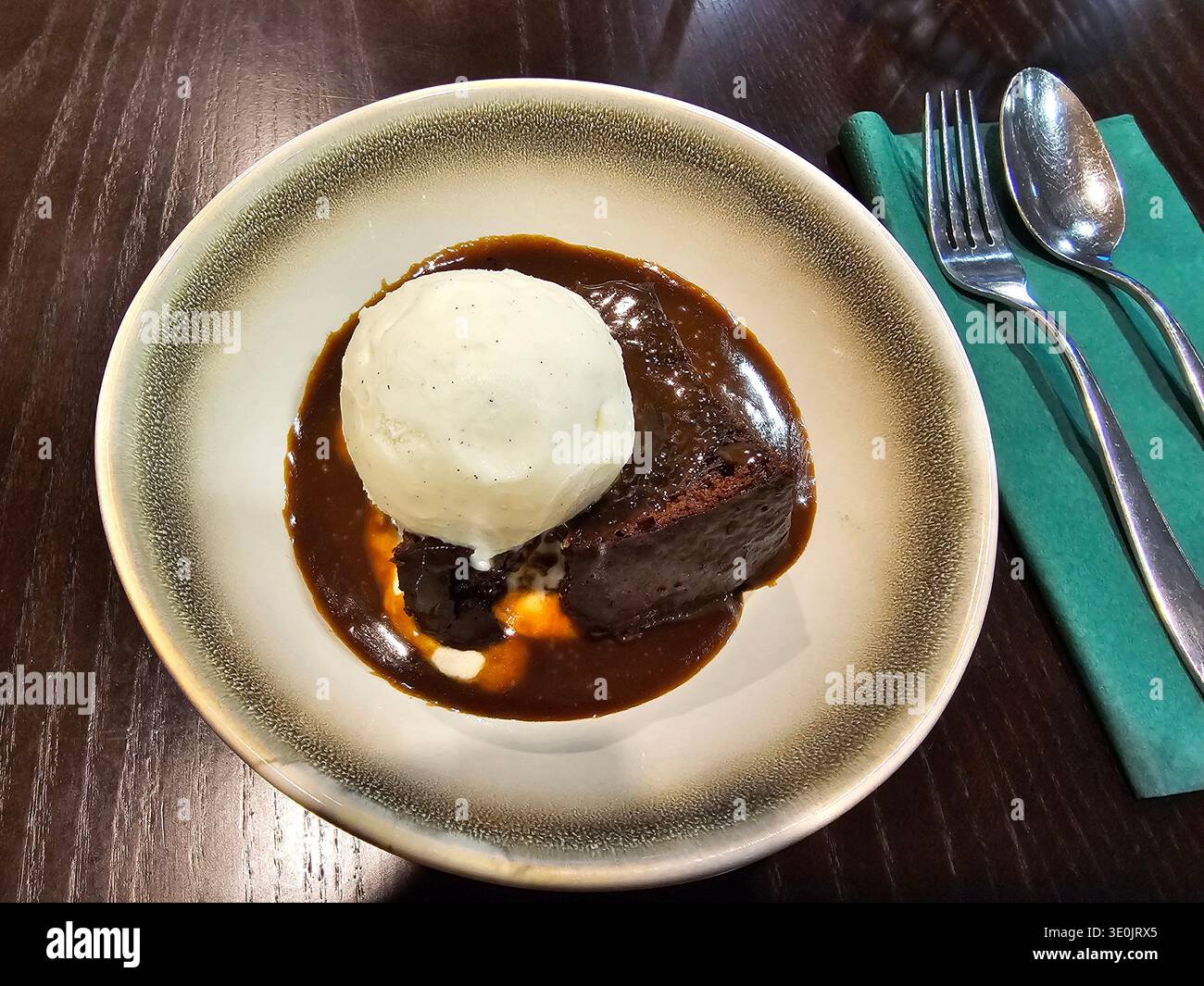 Budino appiccicoso con gelato alla vaniglia, un popolare dessert britannico tradizionale. Foto Stock