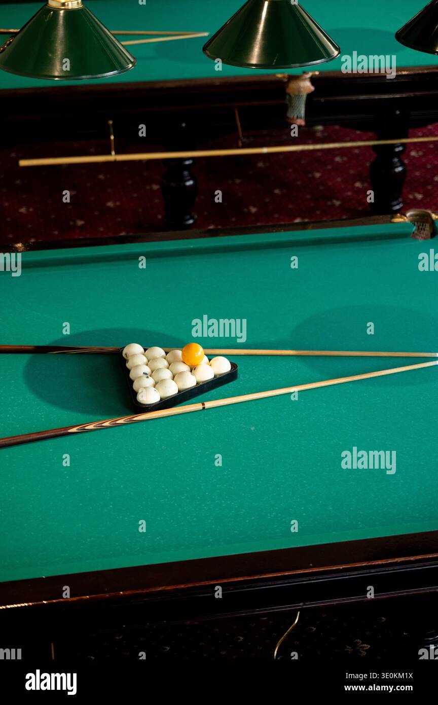 Palline e spunti per giocare a snooker sul tavolo da biliardo verde. Giocare a biliardo sportivo. Gara di biliardo sportivo. Attrezzatura da biliardo Foto Stock