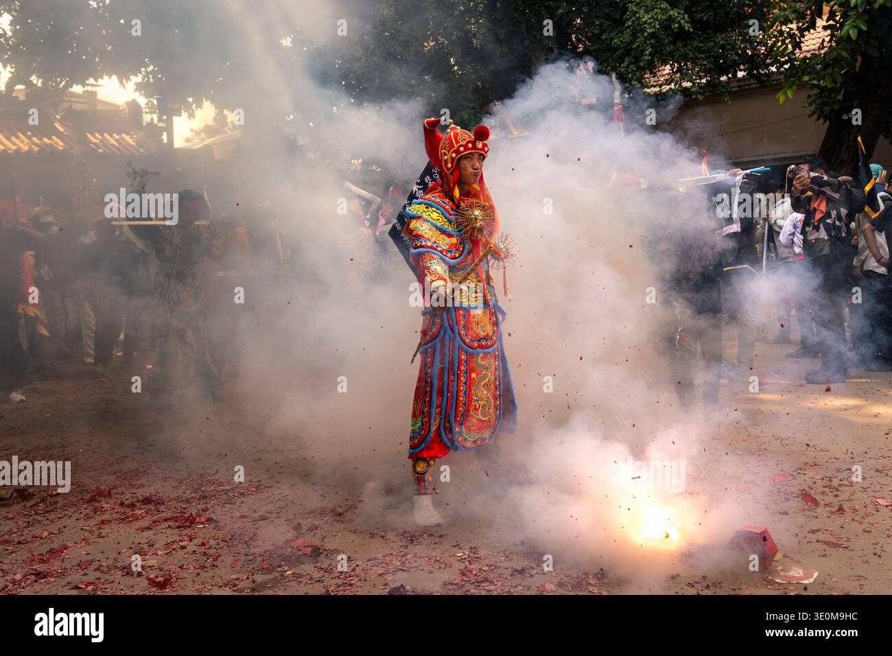Lo spirito con il costume tradizionale decorato cammina attraverso il fumo e i firecrackers durante Hei Neak Ta. Foto Stock