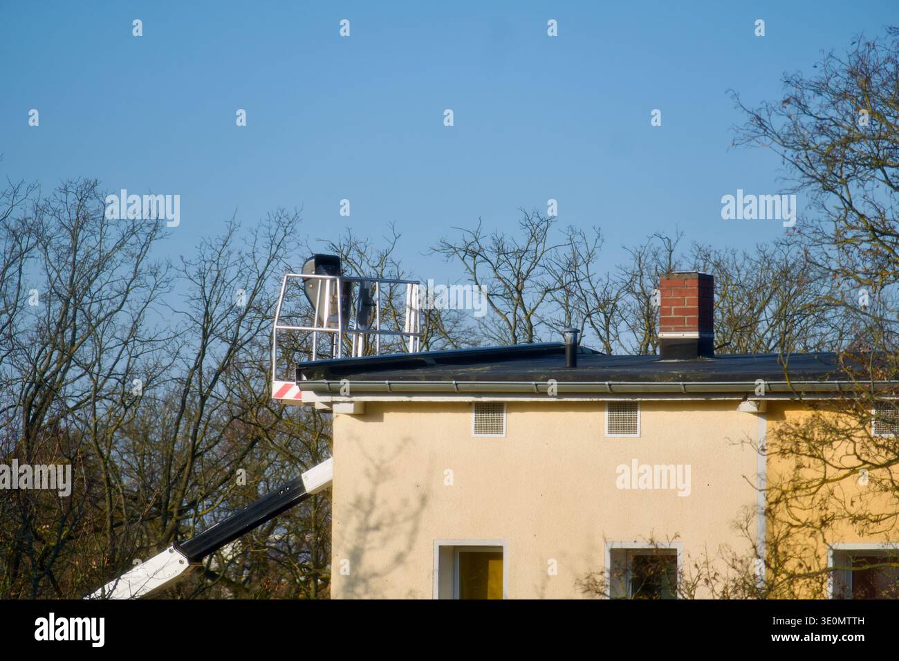 Un spazzacamino professionista che lavora da una piattaforma elevabile Foto Stock