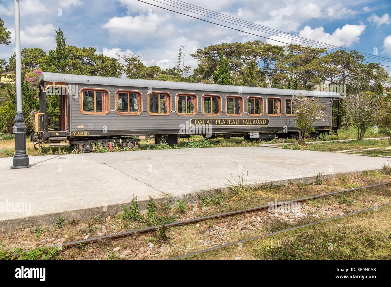 Una lunga carrozza ferroviaria parcheggiata alla stazione ferroviaria di da Lat. Foto Stock