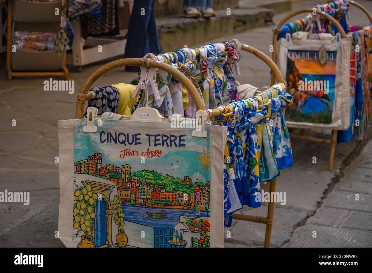 Borse e sciarpe colorate souvenir esposte in vendita in una strada acciottolata a Vernazza, cinque Terre, Italia. Foto Stock