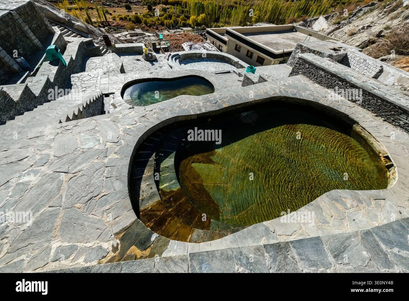 Terrazze in pietra e bagni termali all'aperto presso le sorgenti termali di Panamik offrono una vista sugli alberi autunnali della valle. Foto Stock