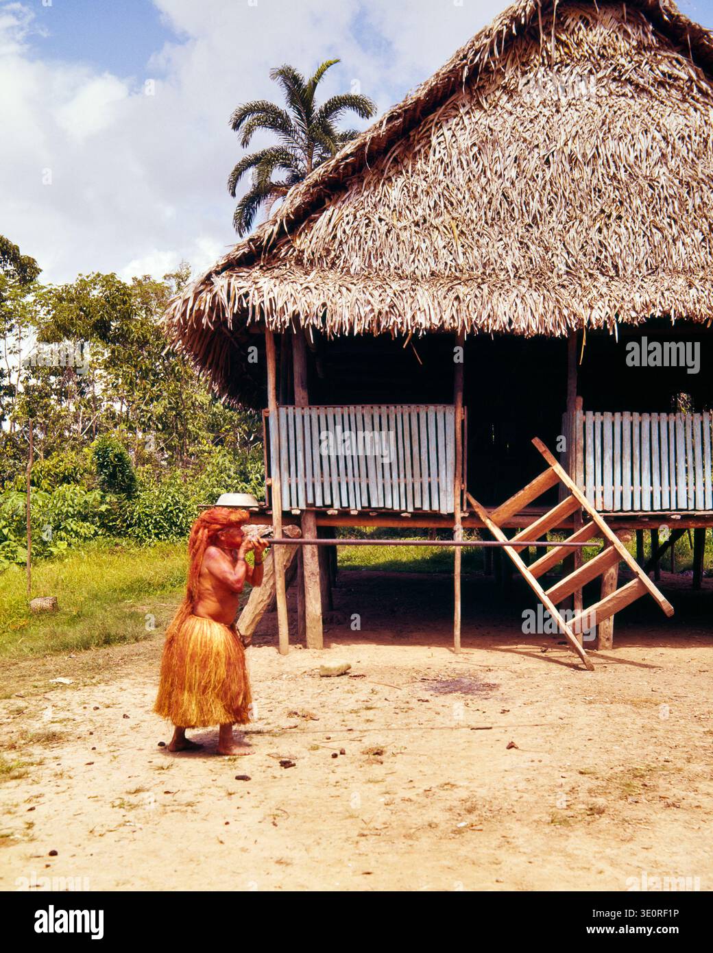 UN UOMO DEGLI ANNI '1960, STREGONE NATIVO DEGLI INDIANI YAGUA LUNGO IL RIO DELLE AMAZZONI, DIMOSTRA COME SPARARE A UN FUCILE VICINO A IQUITOS IN PERÙ Foto Stock