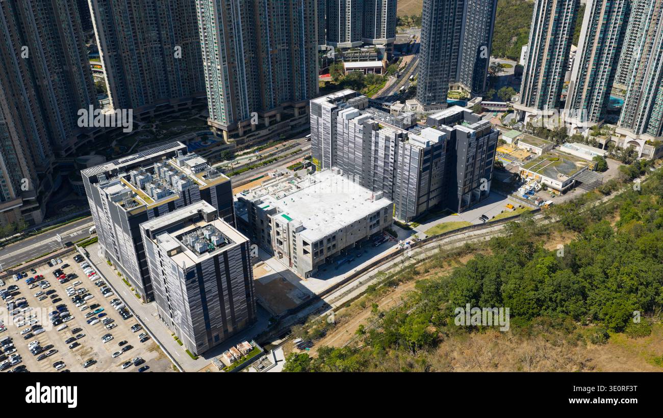 Vista aerea del moderno complesso di data center, contrastata dalle densa torri residenziali circostanti e da una striscia di vegetazione verde, Tseung Kwan o, Foto Stock