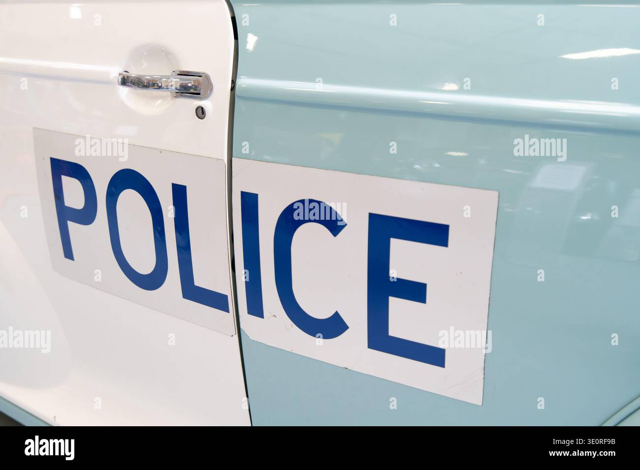 Primo piano di un classico pannello della porta della polizia britannica degli anni '1970 che mostra audaci scritte blu della POLIZIA su carrozzeria bianca e blu pallido Foto Stock