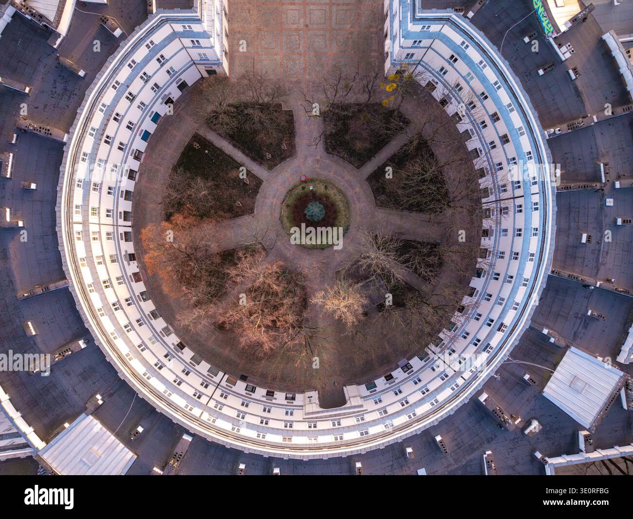 Vista aerea di un edificio circolare che abbraccia un tranquillo cortile con sentieri simmetrici e alberi dormienti all'inizio della primavera, Varsavia, Voivodi delle Masovie Foto Stock